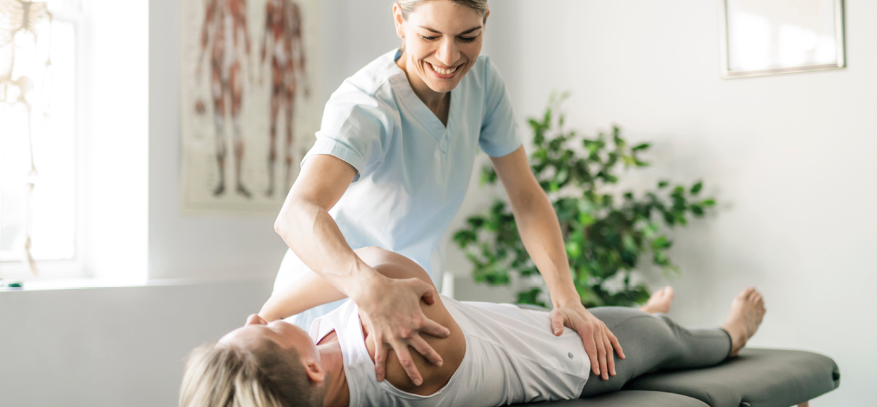 Manuelle Physiotherapie durch Physiotherapeutin bei maennlichem Patient